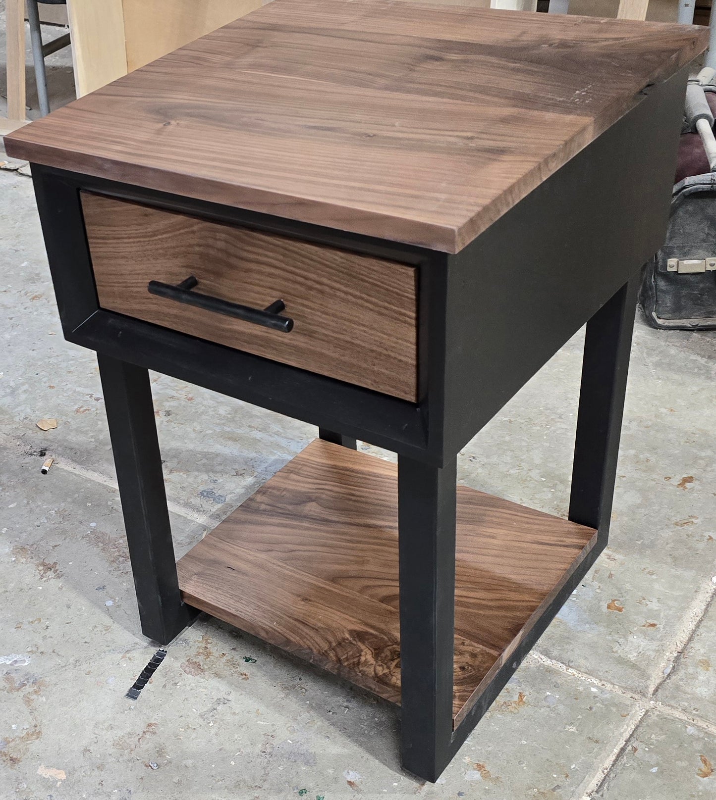 Modern Black and walnut nightstand with drawer and shelf on steel legs.