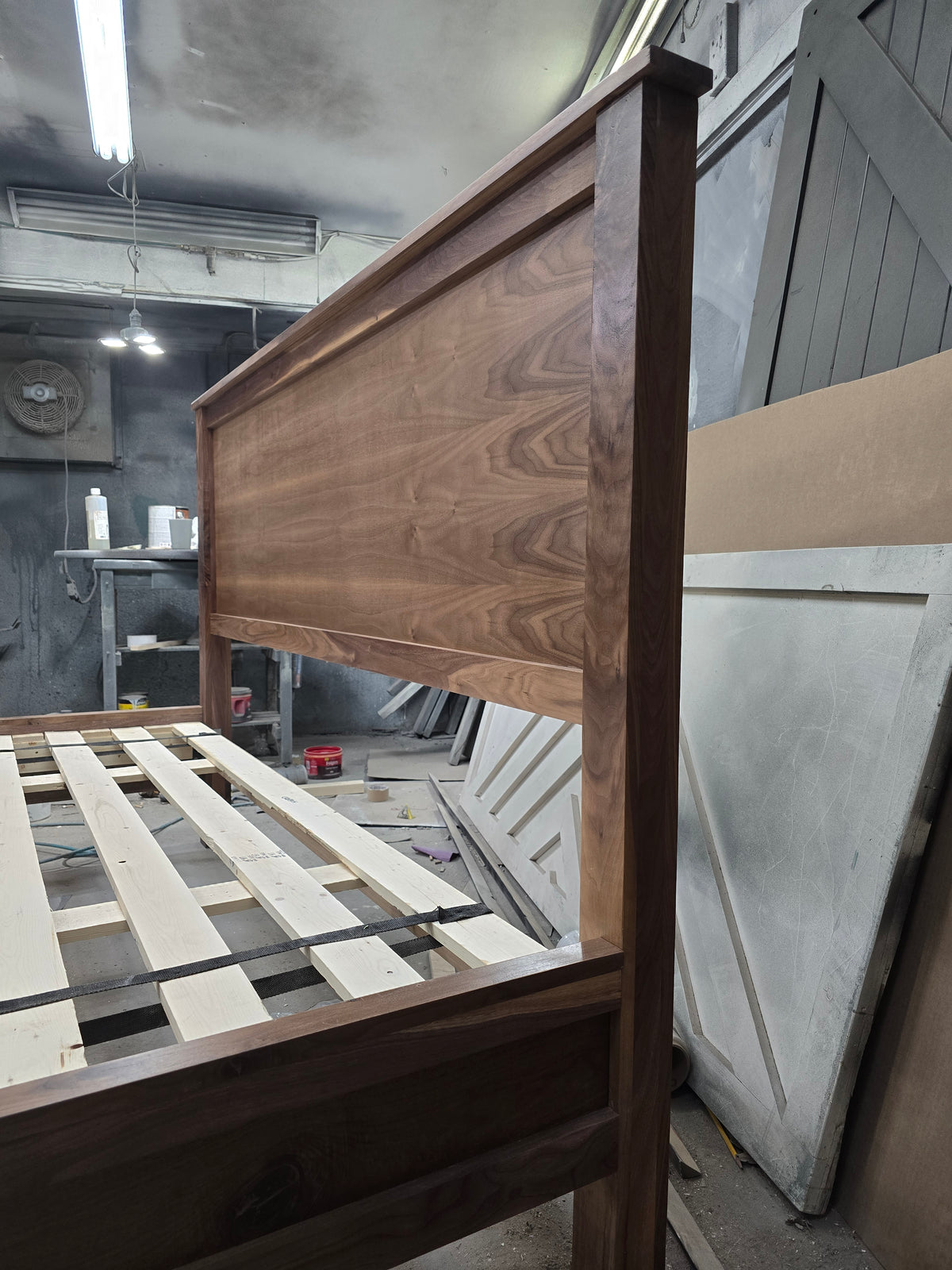 Close view of walnut bed headboard side, wood grain and frame joint in the workshop