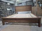 Front workshop view of walnut platform bed with panel headboard and low footboard