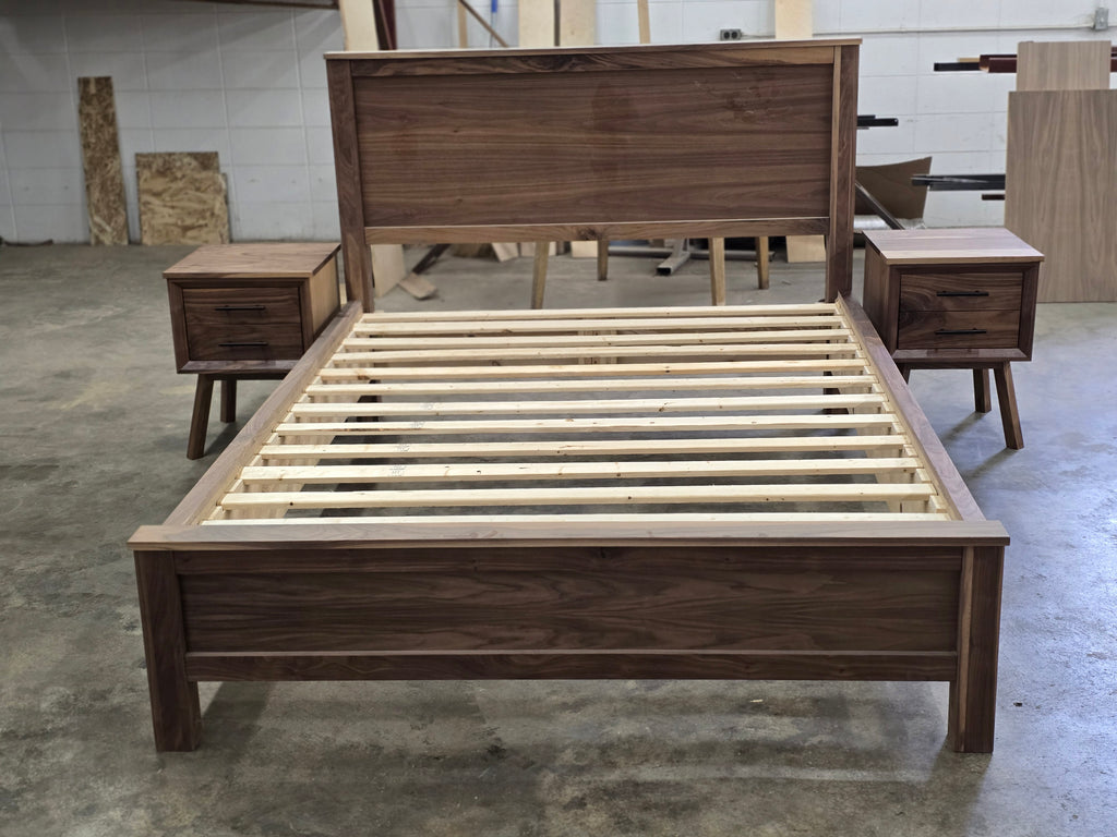 Front view of walnut platform bed and nightstands with the slat base visible