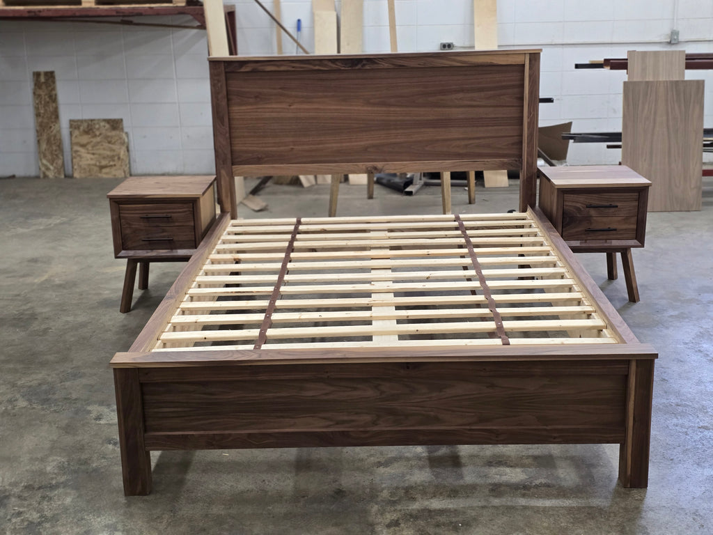Walnut bed headboard, footboard and slat base centered between nightstands