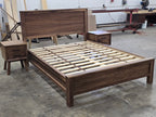 Wide workshop view of walnut bed frame and two nightstands