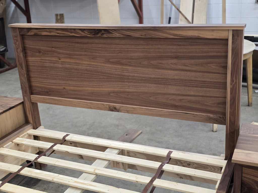 Angled close-up of walnut headboard frame and horizontal wood grain