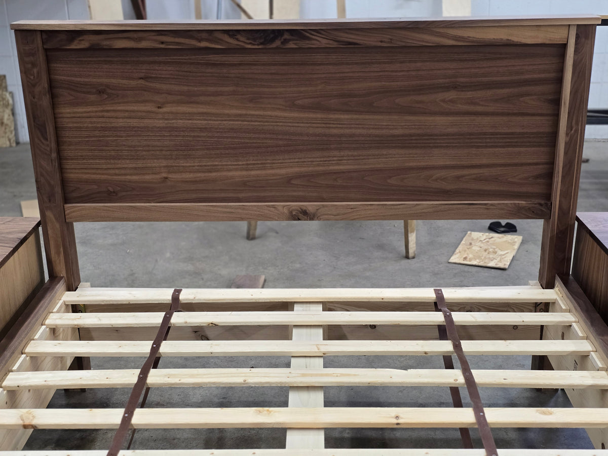 Front close-up of walnut panel headboard and bed slats