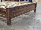 Close-up of walnut bed footboard panel and corner post