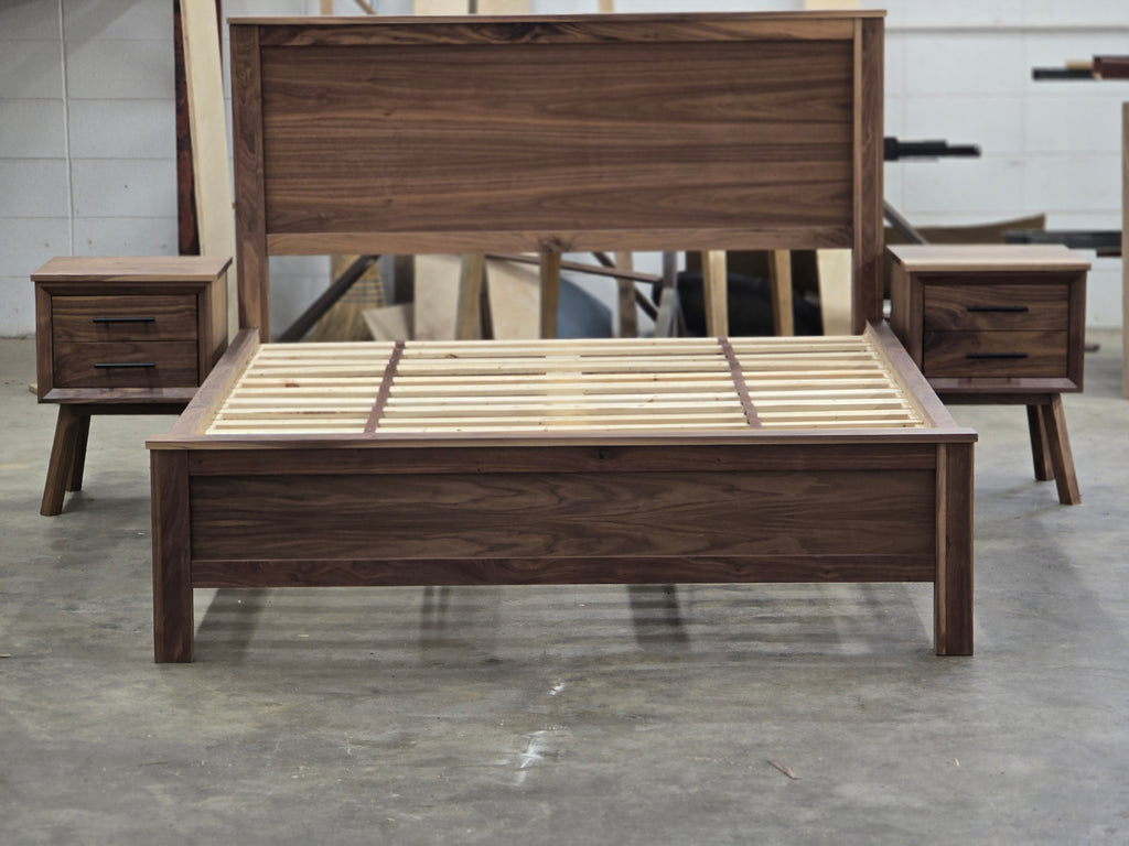 Walnut platform bed flanked by two nightstands in the workshop