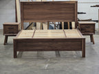 Walnut platform bed flanked by two nightstands in the workshop