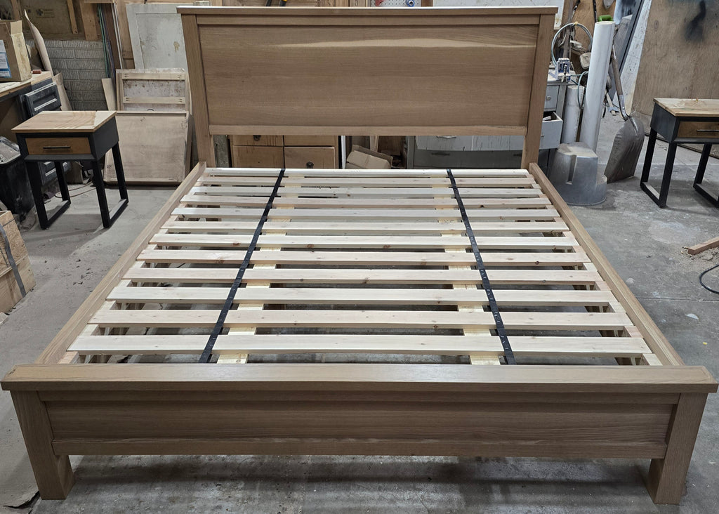 Centered front view of white oak platform bed and panel headboard in the workshop