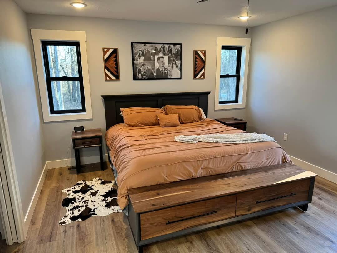 Platform bed with dark headboard and two-drawer storage bench in a furnished bedroom