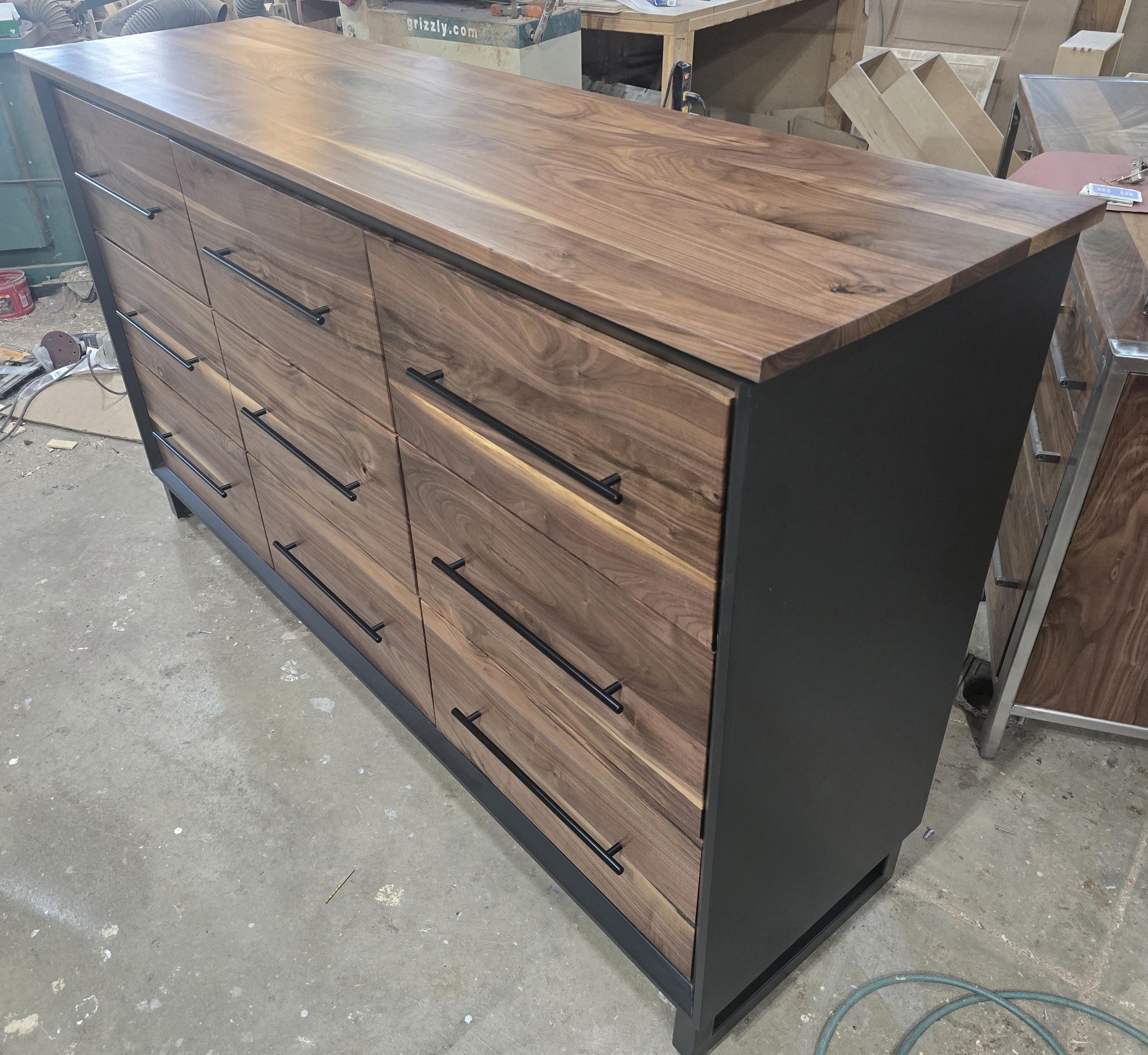 6foot 9 drawer walnut faced modern dresser in black with solid walnut top on steel legs.