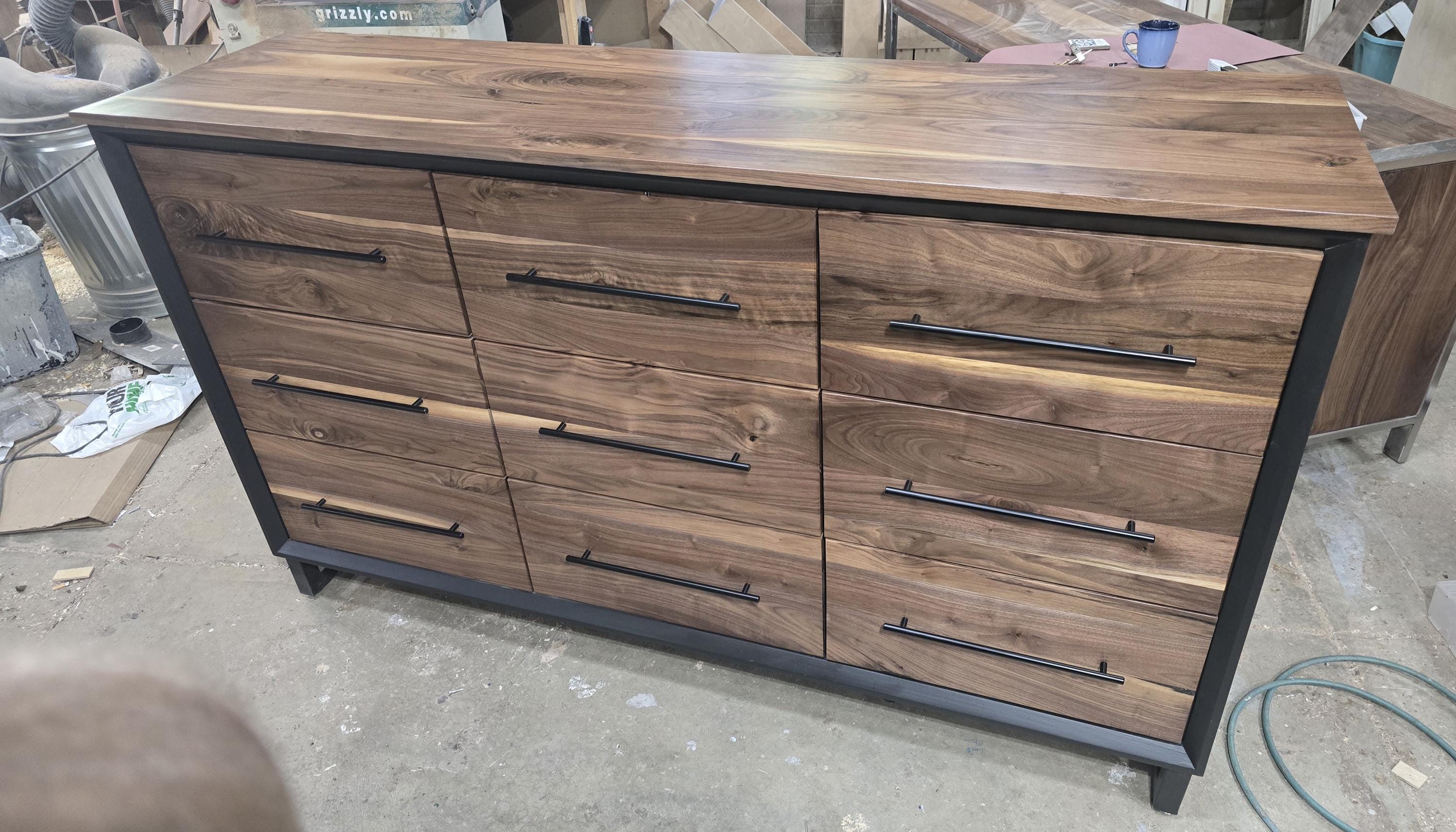 6foot 9 drawer walnut faced modern dresser in black with solid walnut top on steel legs.