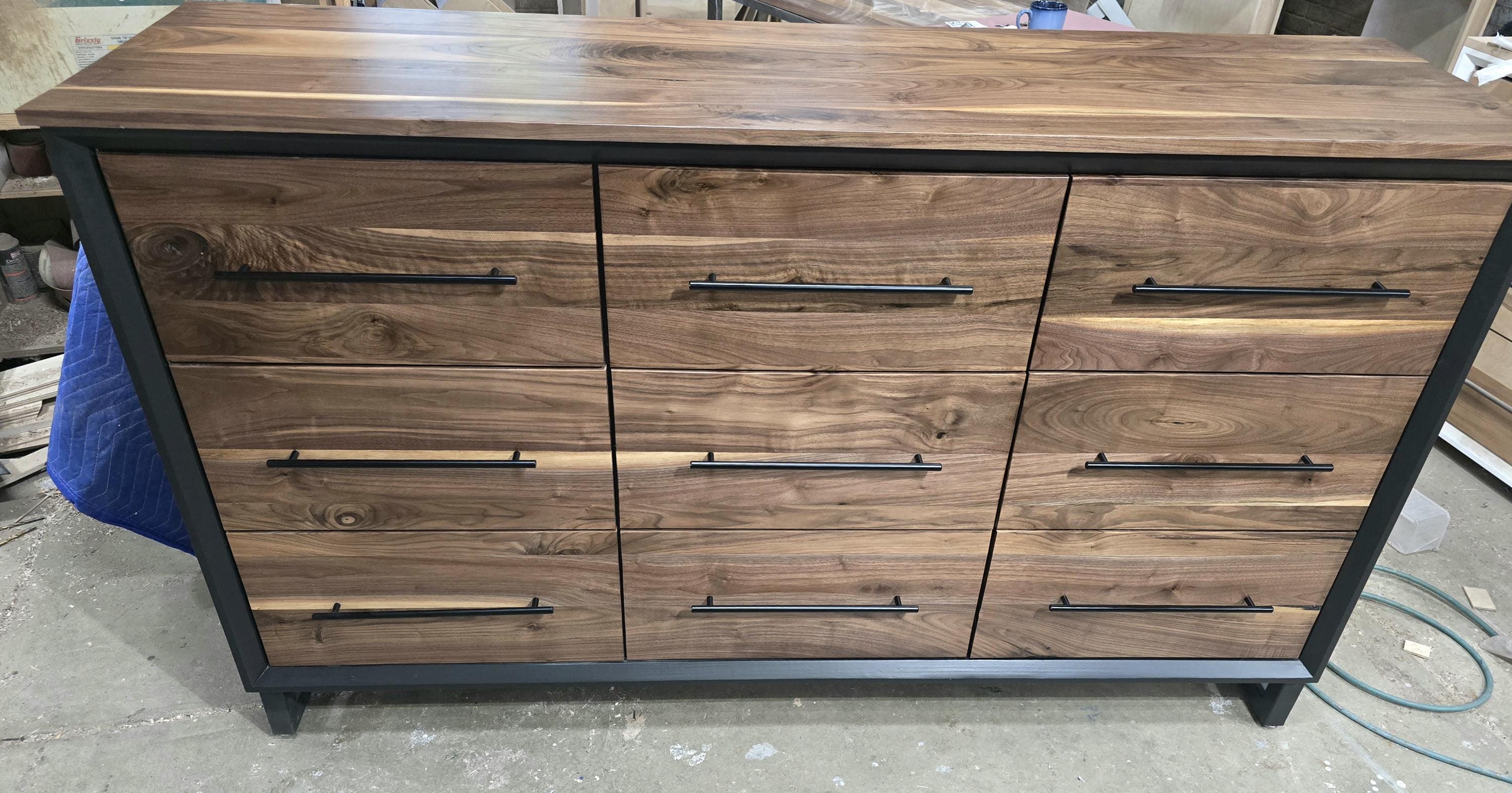 6foot 9 drawer walnut faced modern dresser in black with solid walnut top on steel legs.