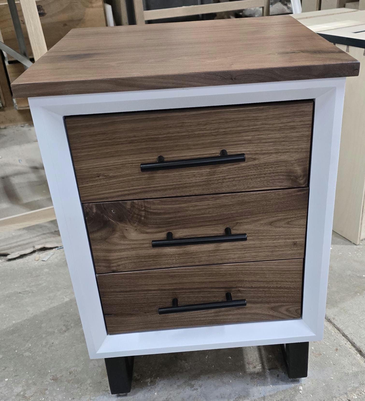 Handcrafted to order. 3 drawer nightstand in a white finish with real walnut fronts and top.